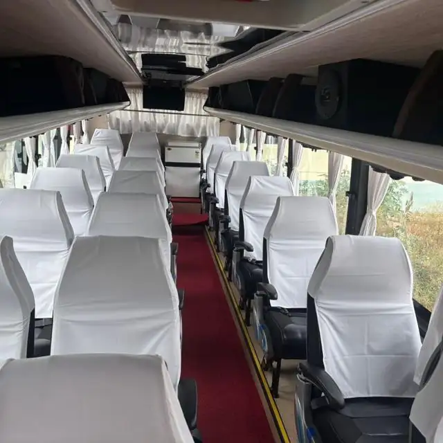 Bus interior with white seat covers and a red carpet