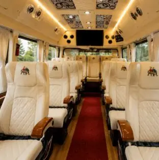 Tempo Traveller interior with cream leather seats and a red carpet