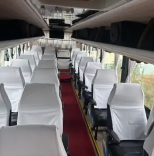 Bus interior with white seat covers and a red carpet